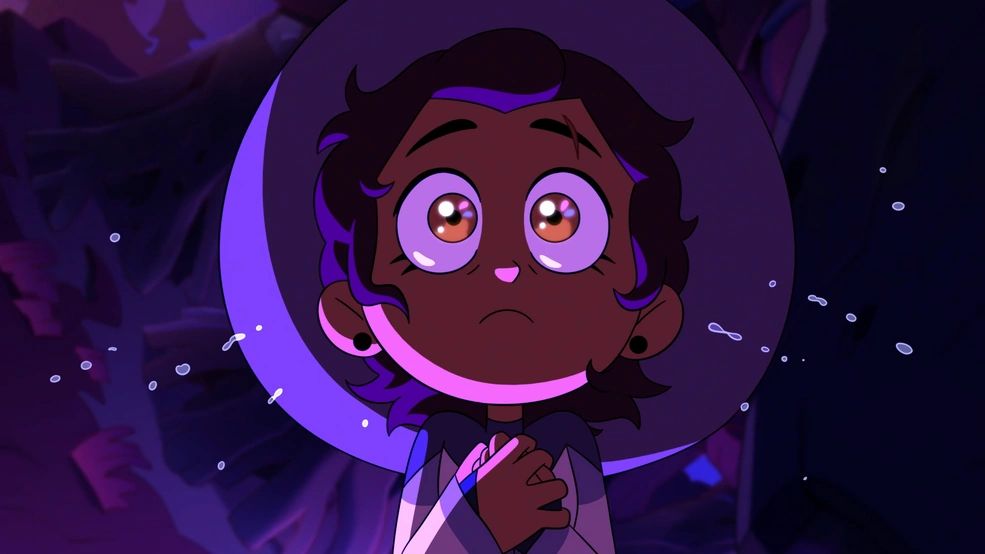 A girl wearing a witch's hat and robes staring forward with a sense of awe